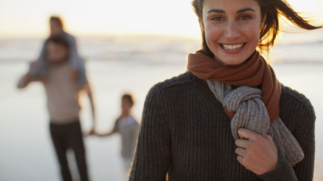Mujer sonriendo con su familia al fondo